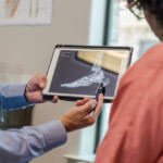 Podiatrist helps explain x-ray to patient