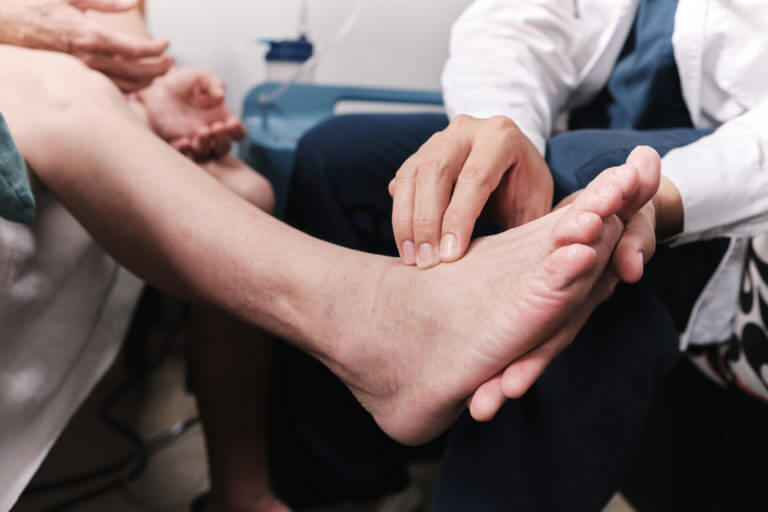 foot and ankle doctor taking patient's pulse in the foot